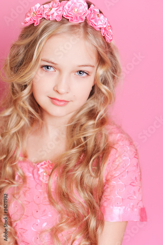 Pretty kid girl posing over pink