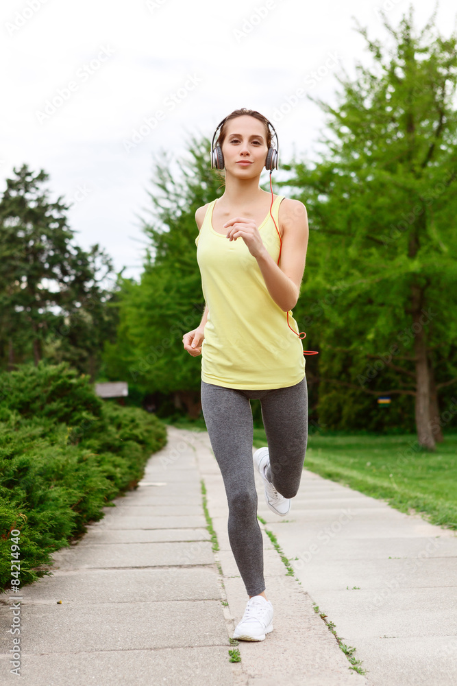 Pretty young woman running in park