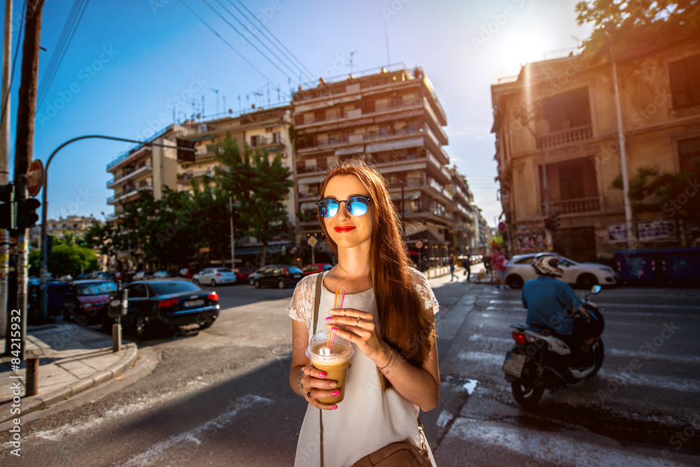 Woman walking on the street with take away coffee 
