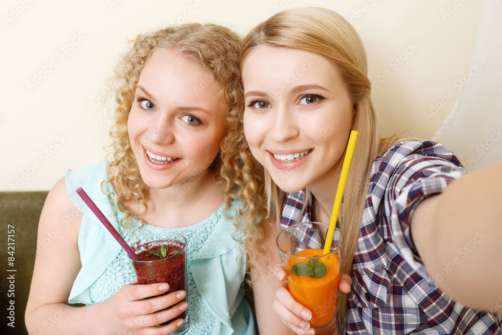 Two smiling girls doing selfie in cafe Two smiling girls doing selfie in cafe