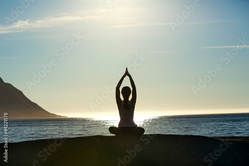 Young woman is practicing yoga between mountains in Norway