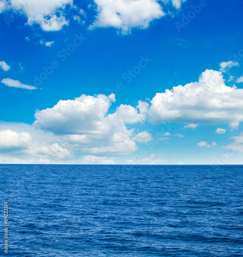 white fluffy clouds with rainbow in the blue sky