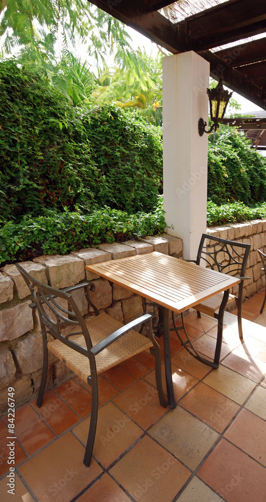 Fototapeta premium table and chairs at a open terrace cafe in the garden, Portugal