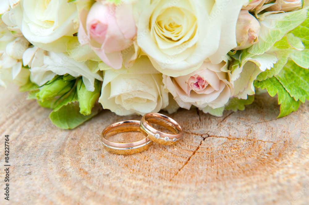  wedding ring on wooden ground with wedding bouquet