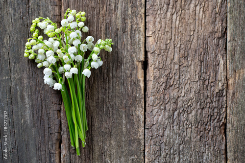 lilly of the valley on wooden surface photo