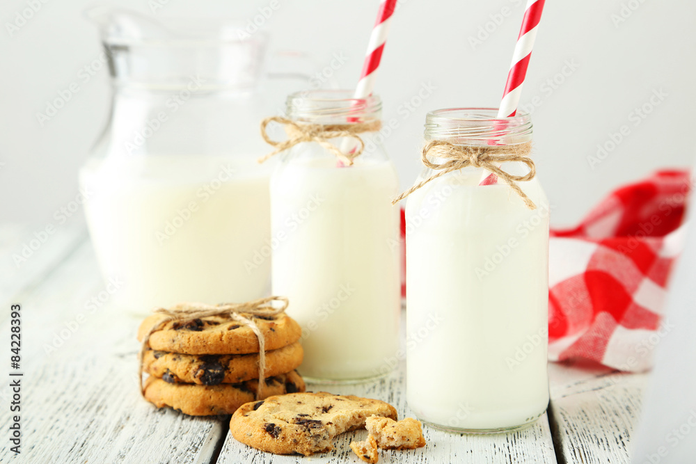 Two bottles of milk with cookies on white background Two bottles of milk with cookies on white background