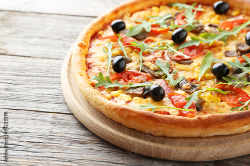 Fresh tasty pizza on grey wooden background