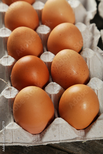 Eggs in the package on brown wwoden background
