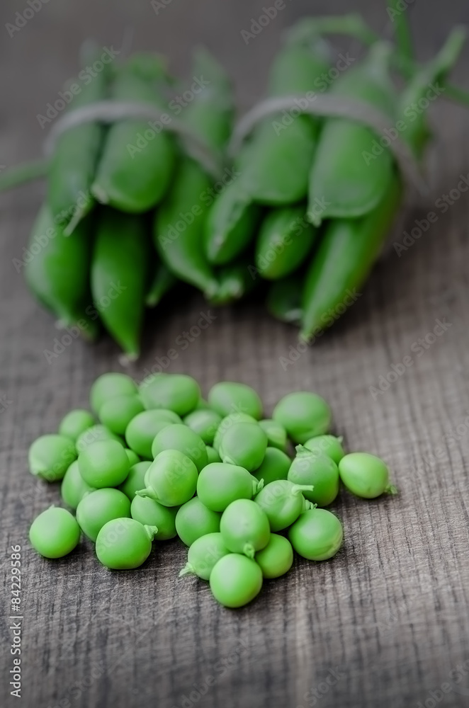 Green organic peas on wooden background, shalow focus Green organic peas on wooden background, shalow focus
