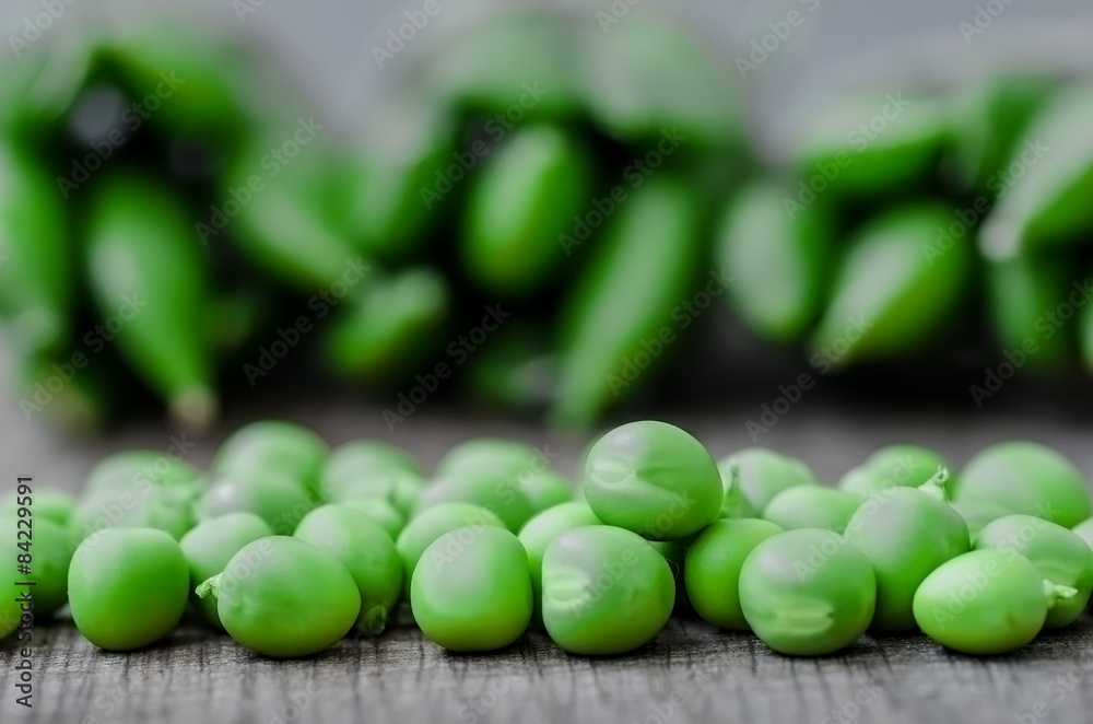 Green organic peas on wooden background, shalow focus Green organic peas on wooden background, shalow focus