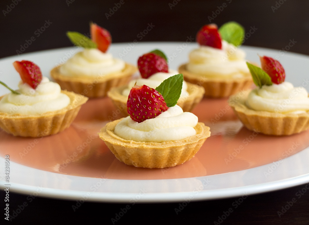 Tiny cupcakes with strawberry, whipped cream, jelly and mint