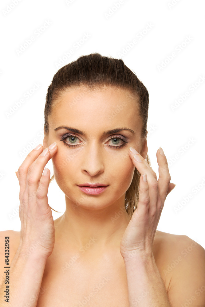Spa woman with make up touching her face.
