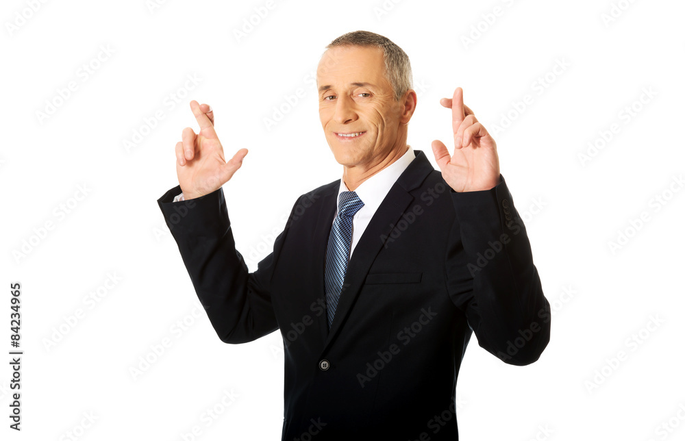 Businessman making a wish with fingers crossed Businessman making a wish with fingers crossed
