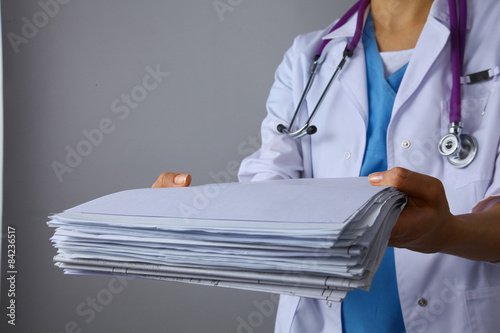 Young female doctor giving a stack of documents 