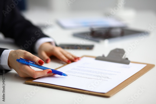 Young woman sitting at the desk with folder