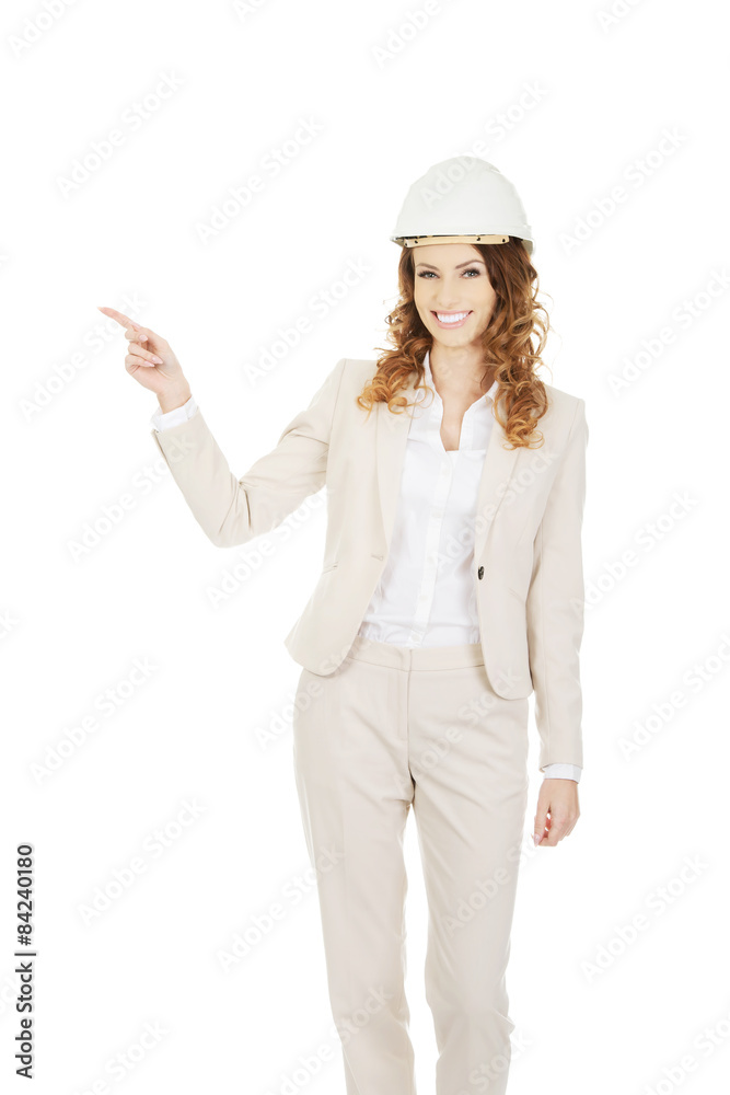 Businesswoman in white helmet pointing up. Businesswoman in white helmet pointing up.