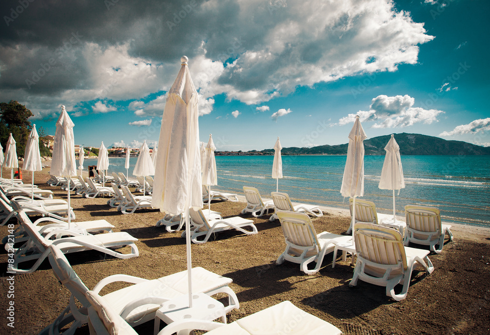 Obraz premium sunchairs with umbrellas on beautiful beach