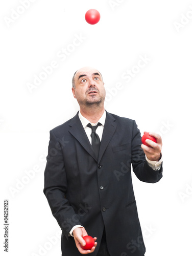 Businessman that is juggling with a red balls
