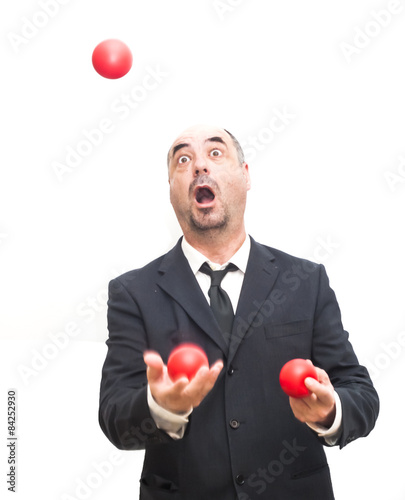 Businessman that is juggling with a red balls