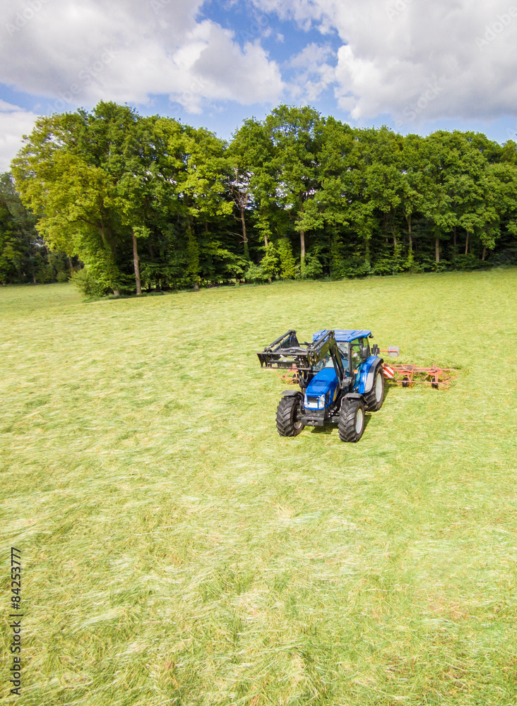Trecker mit Heumaschine beim Schwaden, Vogelperspektive Trecker mit Heumaschine beim Schwaden, Vogelperspektive