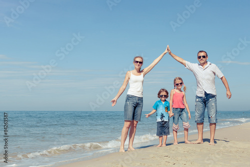 Happy family standing on the beach at the day time.