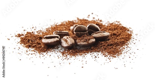 Collected coffee beans with coffee powder on white