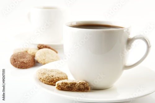 Cups of coffee with cookies and saucer on white