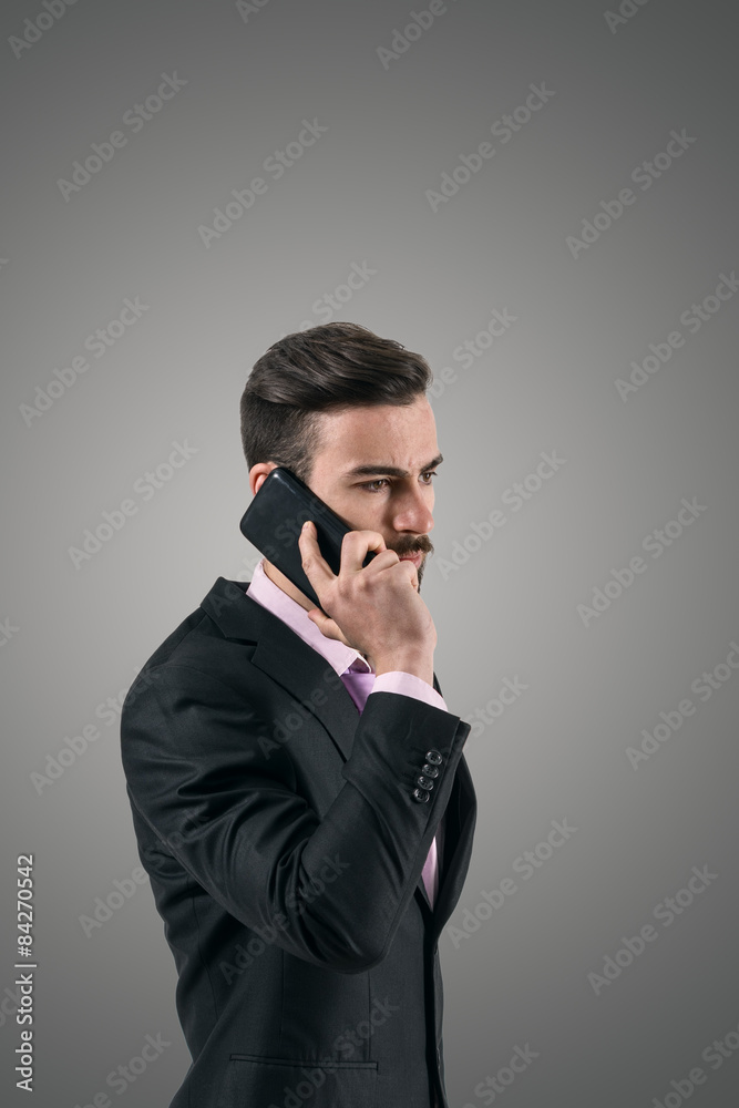 Dramatic portrait of businessman on the cellphone Dramatic portrait of businessman on the cellphone