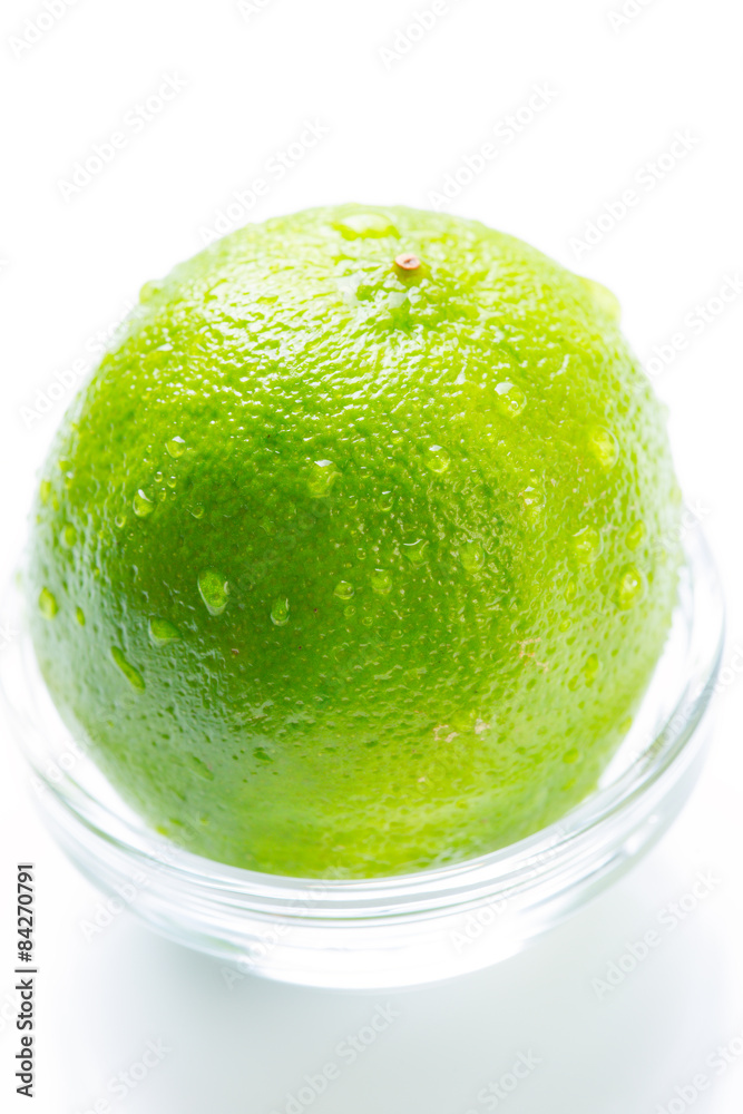 Green lime with water drops in the glass bowl Green lime with water drops in the glass bowl