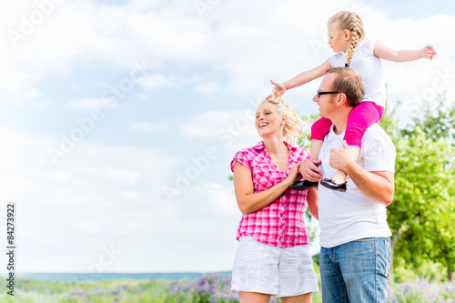 Family having summer walk on meadow outdoors
