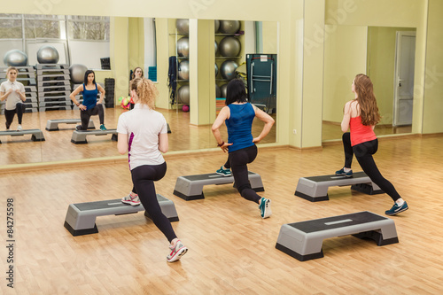 Group of women making step aerobics from the backside