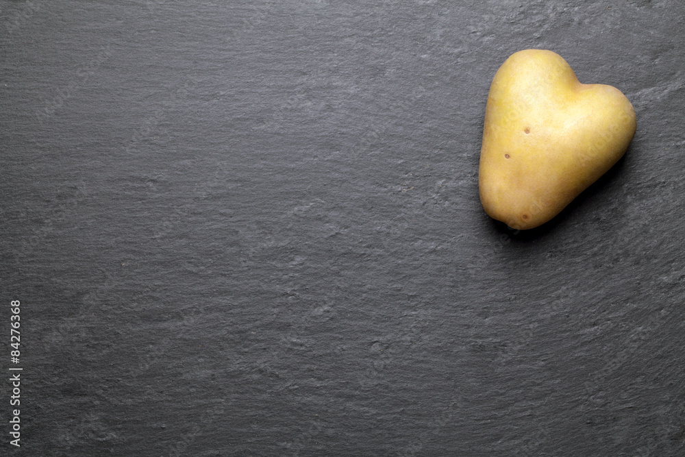 Obraz premium heart potato with a black graphite background