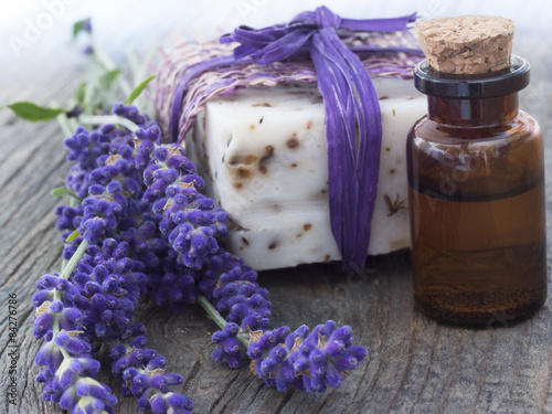 Fototapeta Naklejka Na Ścianę i Meble -  lavender oil with fresh flowers on the wooden table