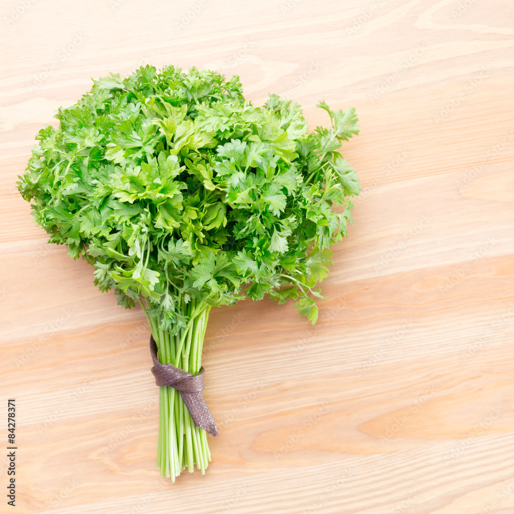 Fresh parsley on a light wooden background Fresh parsley on a light wooden background