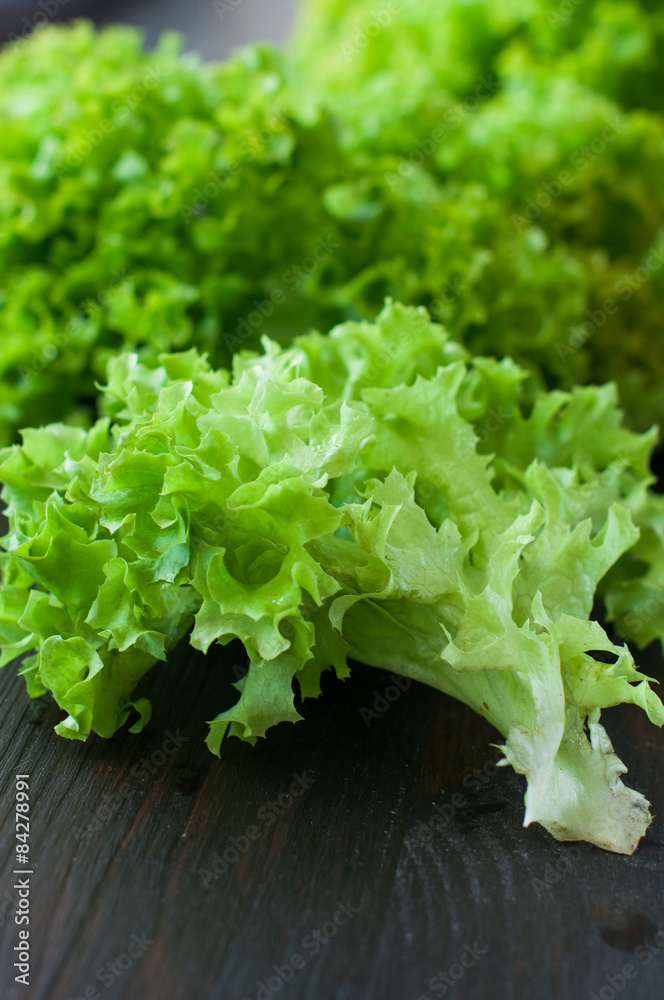 fresh green salad leaves (lettuce) on black wooden table fresh green salad leaves (lettuce) on black wooden table