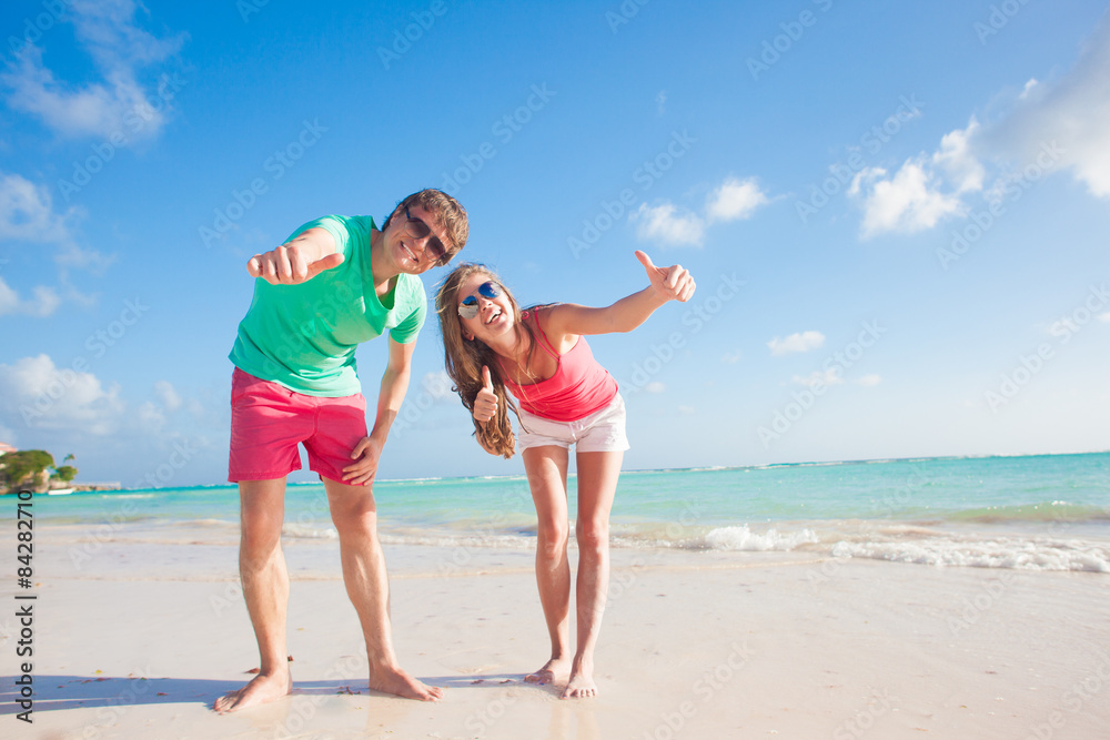 back view of happy romantic young couple hugging on the beach
