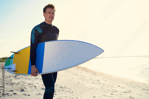 Photography Handsome sporty surfer posing with his surfboard