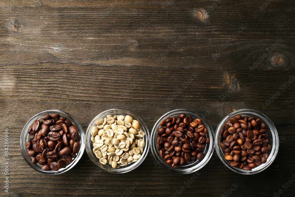 Coffee beans in saucers on wooden background Coffee beans in saucers on wooden background