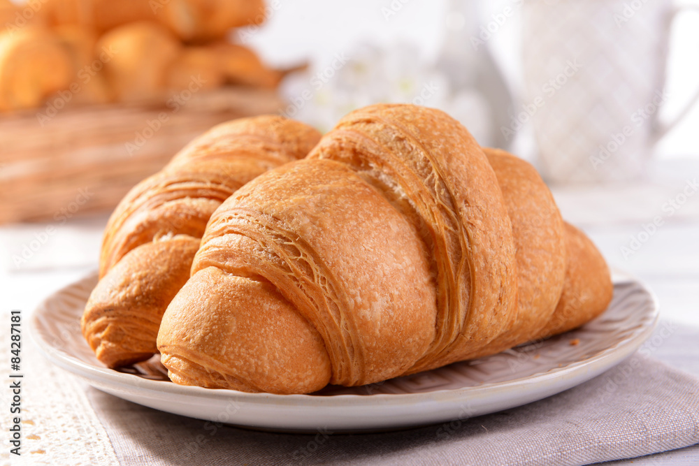 Fototapeta premium Delicious croissants on plate on table close-up