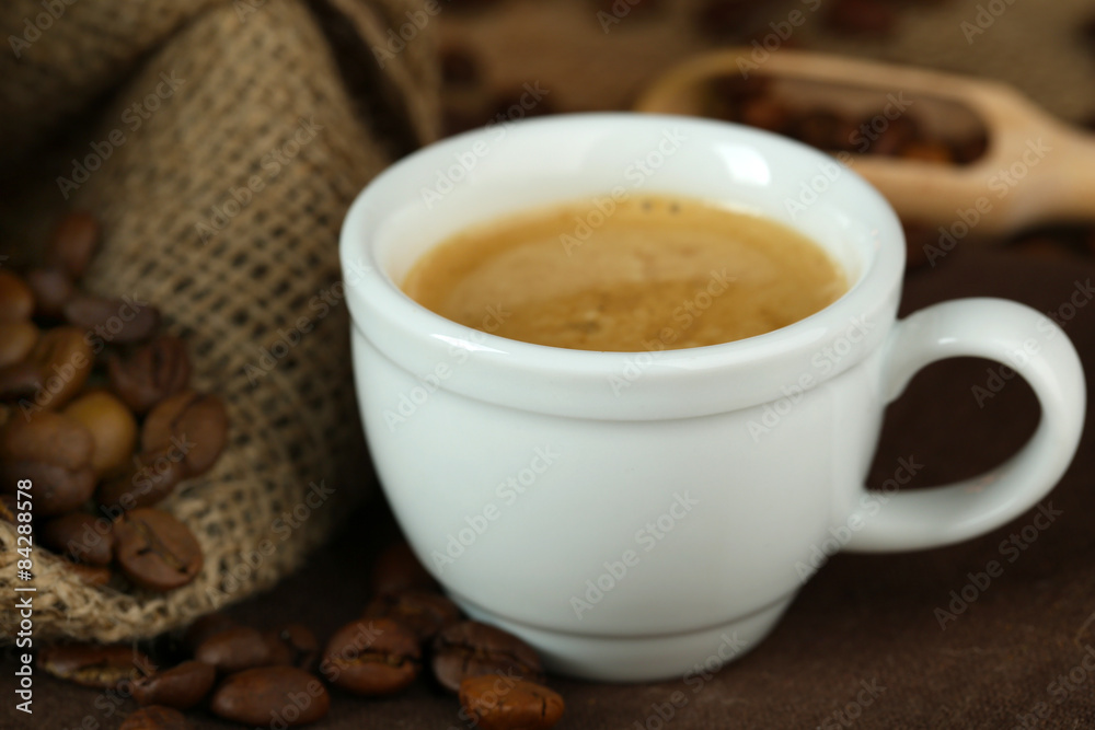 Cup of coffee with beans on table close up Cup of coffee with beans on table close up