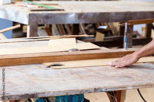 carpenter use saw cut wood for make new furniture