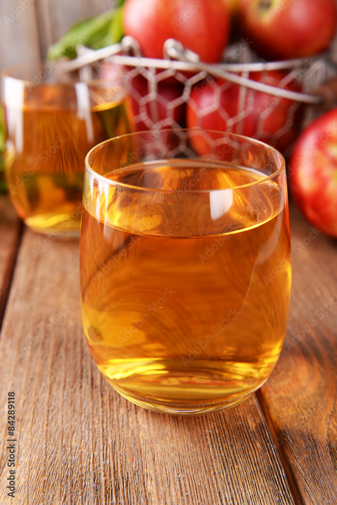 Glasses of apple juice on wooden table, closeup Glasses of apple juice on wooden table, closeup