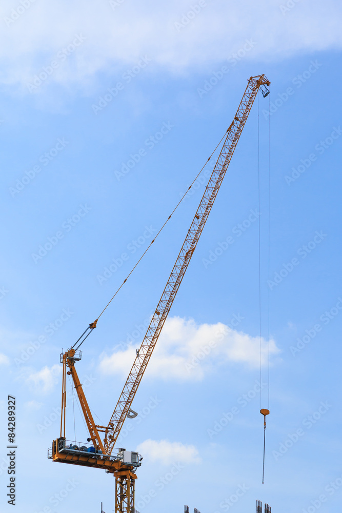 Building crane and construction site under blue sky