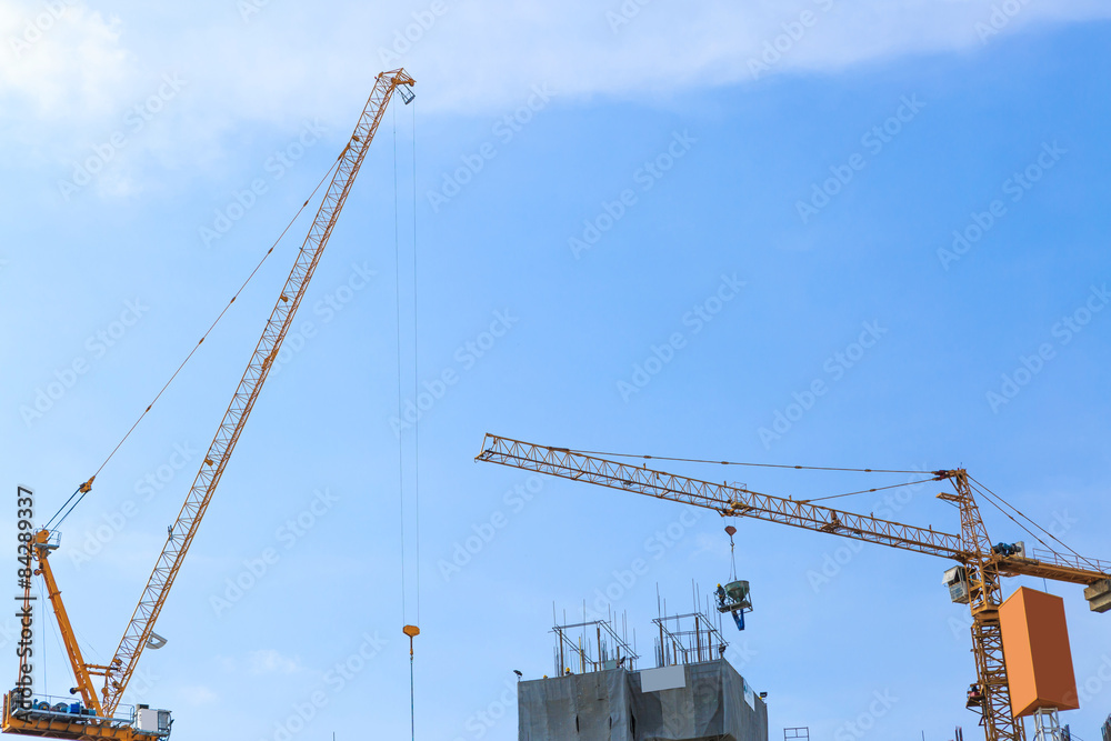 Building crane and construction site under blue sky