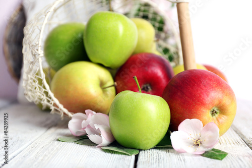 Fresh apples with apple blossom on wooden table