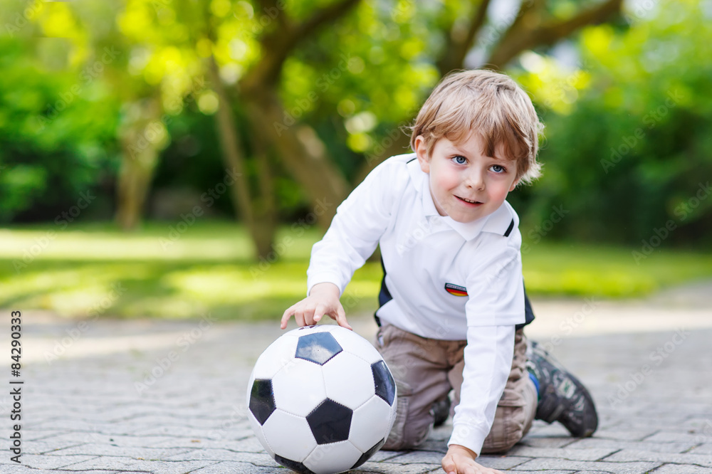 Two little sibling boys playing soccer and football Two little sibling boys playing soccer and football