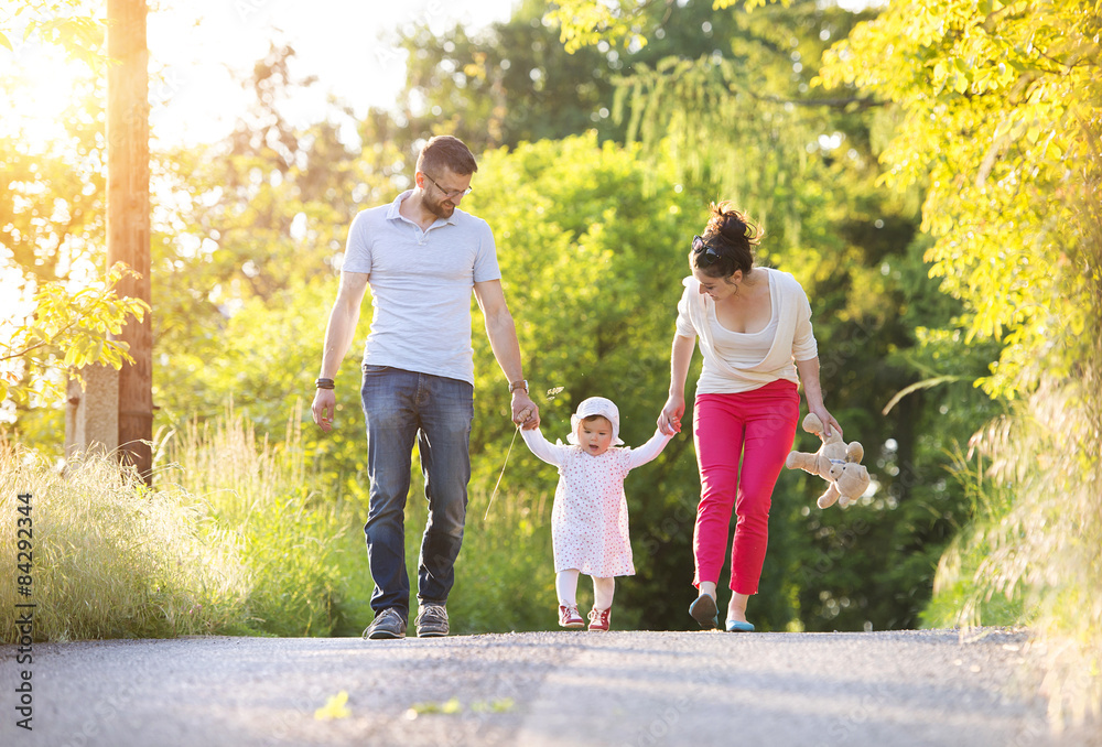 Obraz premium Beautiful young family enjoying time in outside in summer nature