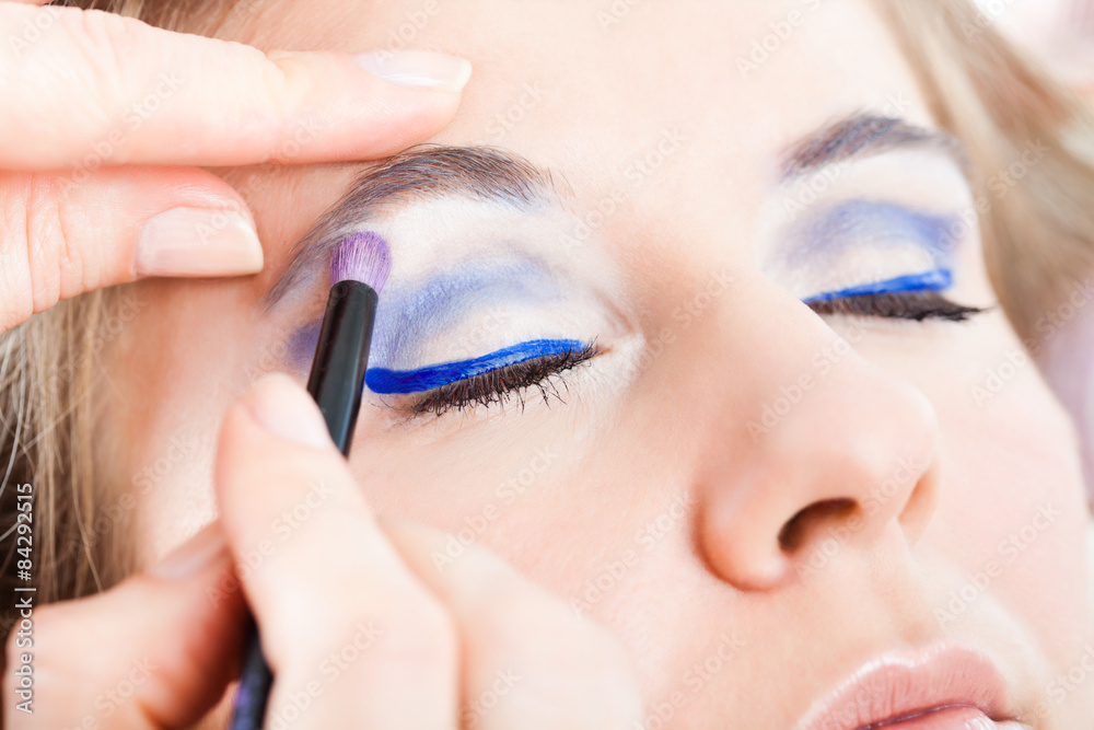 Beautician artist applying make-up