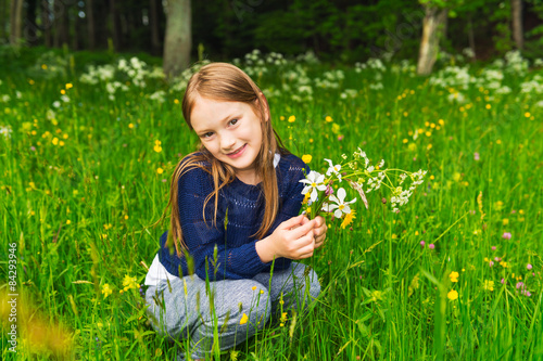 Cute little girl picking wildflowers