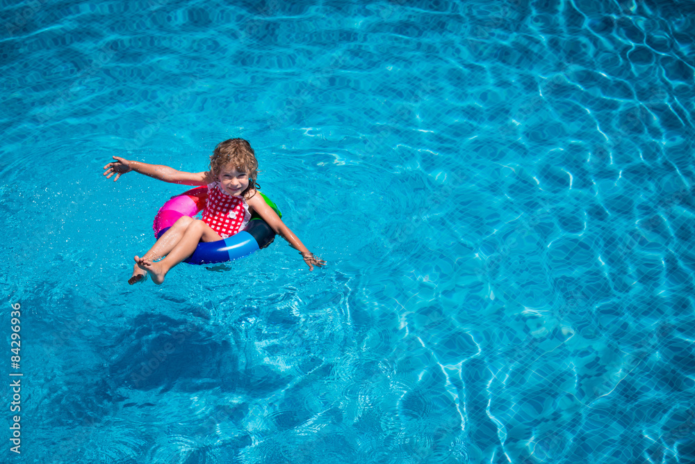 Happy child playing in swimming pool